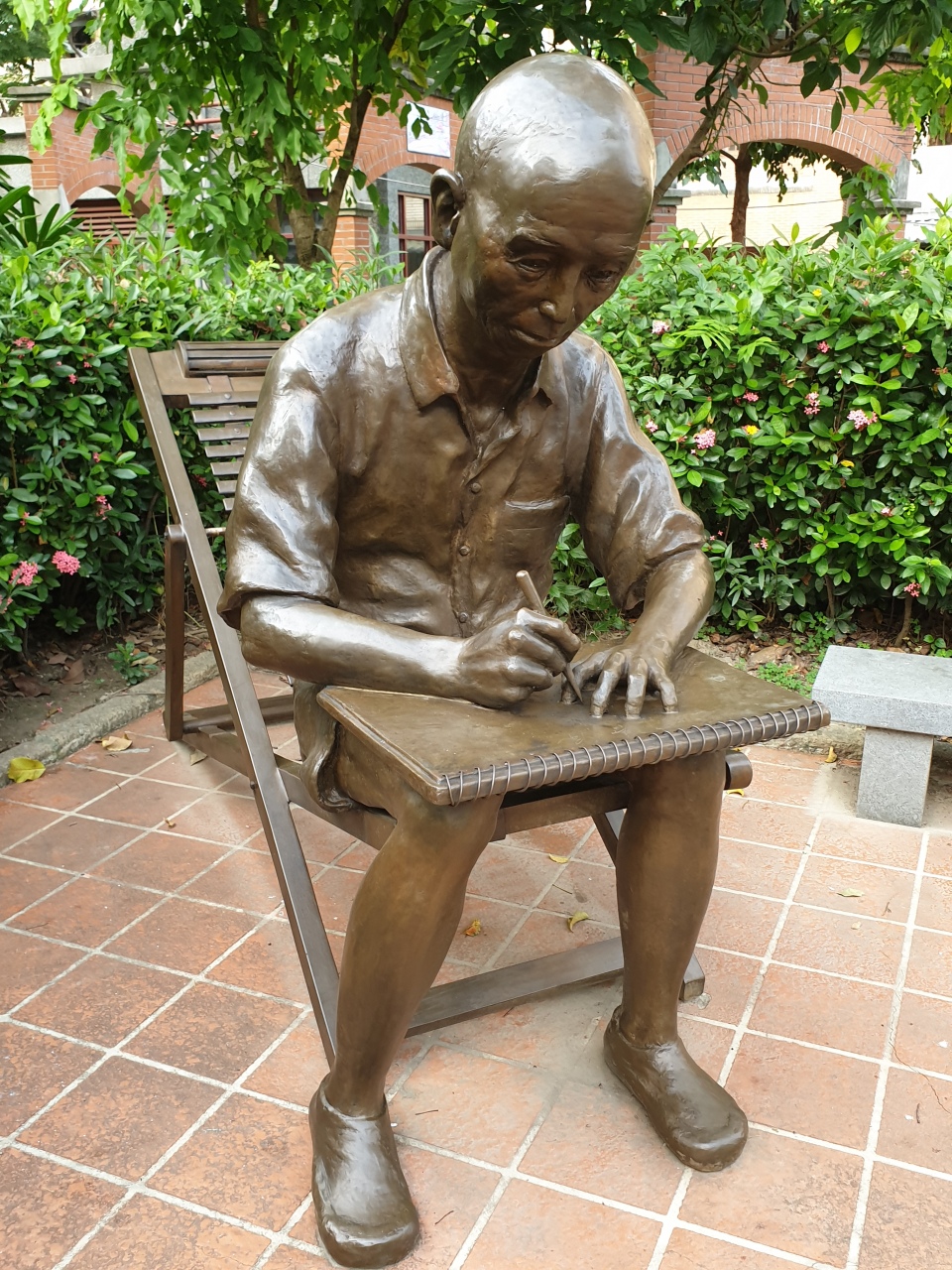 《望春風》作詞人李臨秋雕塑，模擬他在大稻埕的淡水河畔埋頭寫詞的生活。